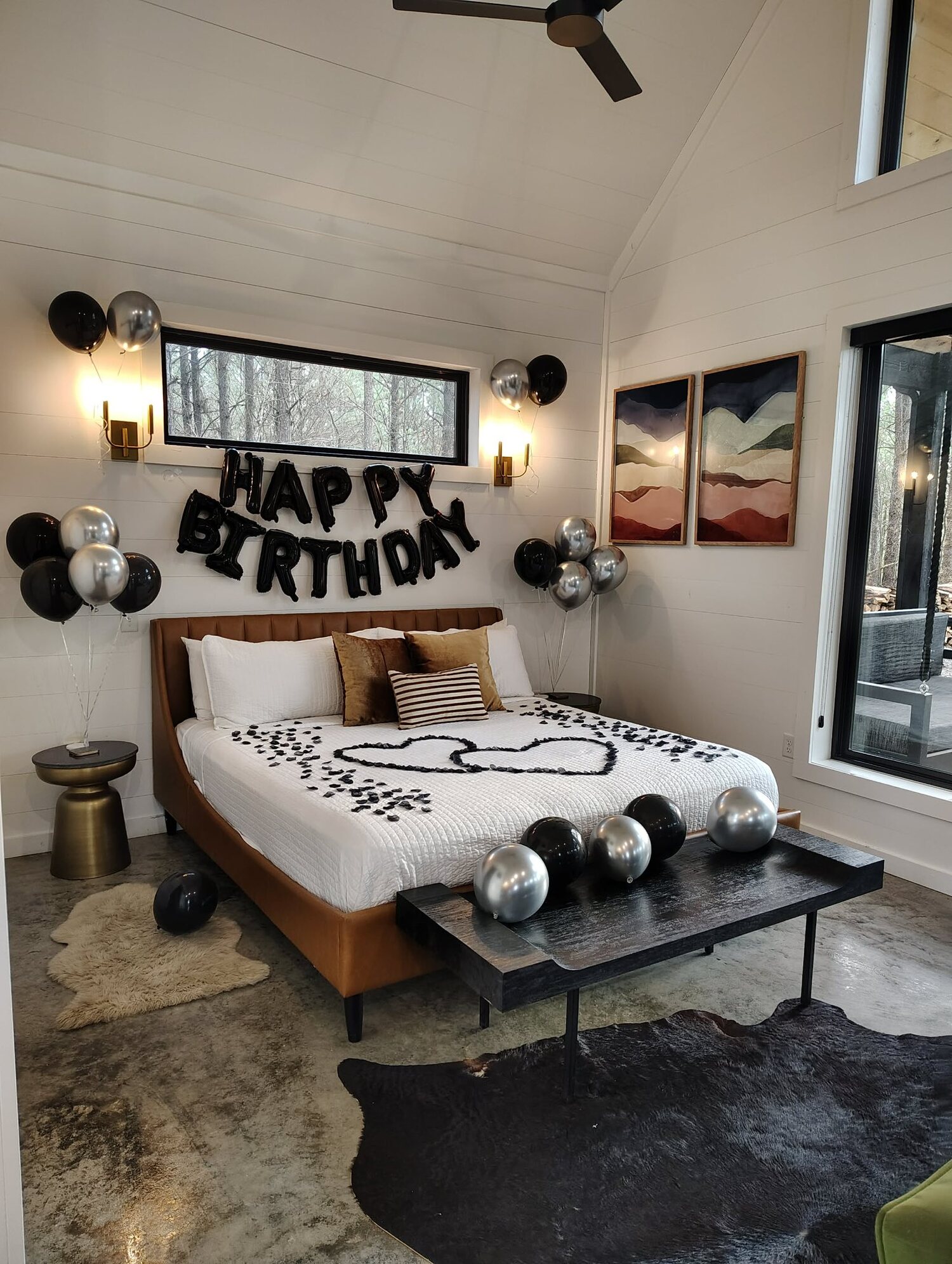 Wide view of the balloon-and-petal birthday setup with vaulted ceiling at The Vine cabin